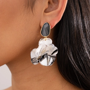 Détail des boucles d'oreilles fleur en résine avec motif marbre et bords dorés