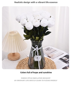 Realistic white roses in a gray glass vase with a ribbon on a wooden table setting