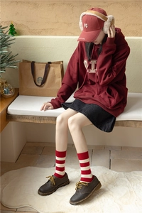Close-up of red and white striped cashmere socks paired with dark brown leather shoes
