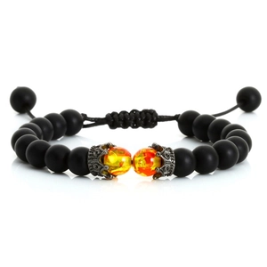 Detail of matte black beads and crown charm with orange tiger eye stones on woven bracelet