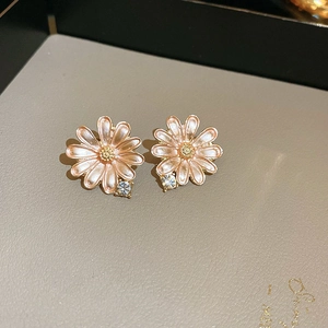 Detail of pink enamel daisy stud earrings with sparkling crystal accents and gold finish
