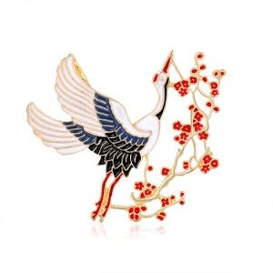 Macro shot of detailed crane and plum blossom enamel brooch with gold-tone plating