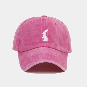 Close-up of pink washed cotton baseball cap featuring detailed white rabbit embroidery