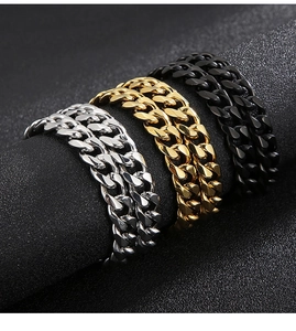 Close-up of cuban link bracelets in silver, gold, and black with polished finish