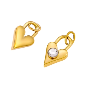 Macro detail of gold heart-shaped pendants with one piece featuring clear cubic zirconia