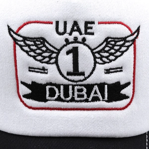 Détail d'une casquette blanche avec écusson brodé UAE et DUBAI et motif d'ailes