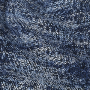 Close-up of blue and white knitted plush fabric with soft fuzzy texture and knit patterns