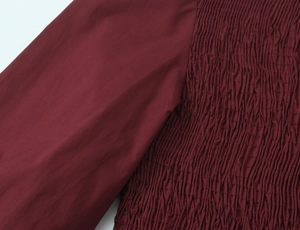 Vue détaillée de la texture nid d'abeille bordeaux et de la broderie élastique smockée