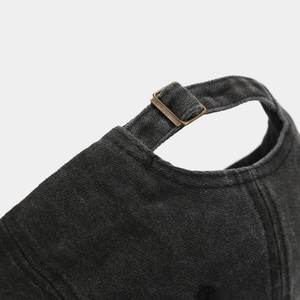 Detail of adjustable metal buckle and washed cotton texture on vintage baseball cap