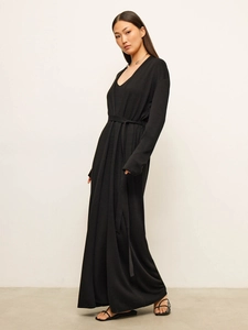 Detail of a black V-neck maxi dress featuring a matching waist belt and soft knit texture