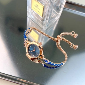 Detail of rose gold quartz watch featuring a blue enamel bracelet and adjustable drawstring