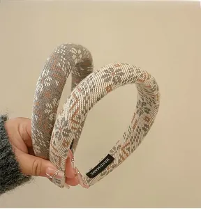 Detail of woven floral headband featuring handmade labels and winter snowflake patterns