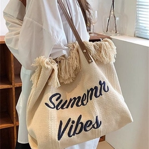 Off-white woven tote bag with Summer Vibes embroidery, tassels and leather straps