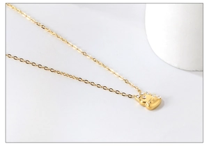 Gros plan d'un collier doré avec un pendentif scintillant serti de strass