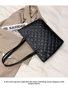 Classic black quilted tote bag with long straps displayed in a professional work setting