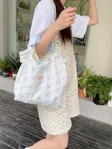 Floral teddy bear canvas tote bag with light blue rope handles and woven label