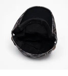 Detail view of the warm fleece lining and plaid fabric of this British newsboy cap