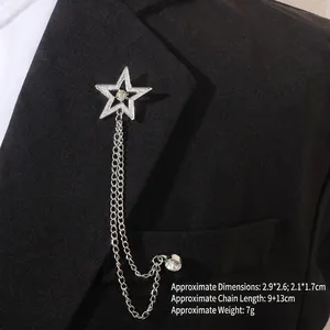 Gros plan d'une broche étoile avec chaînettes argentées sur le revers d'un blazer noir