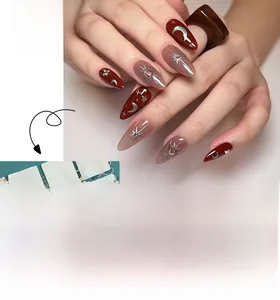 Detailed macro view of almond wine red press-on nails with silver moon and star accents