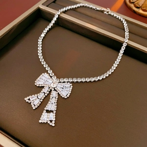 Macro shot of a silver bow necklace with sparkling zircon stones in a gift box