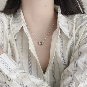 Detailed view of tricolor interlocking rings pendant on a silver necklace chain