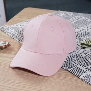Classic light pink plain baseball cap in twill cotton on a rustic wooden table background