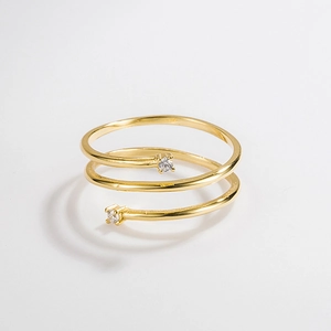 Close-up of a double-layered golden ring with sparkling zircons on a white background
