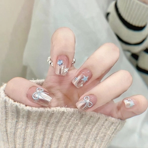 Nœud bleu et décorations d'étoiles sur des faux ongles français élégants effet jelly