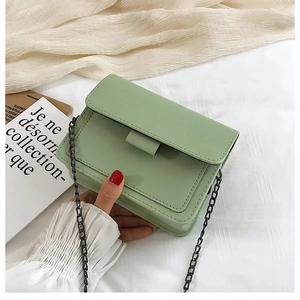 Detail of mint green matte leather small square bag with black metal chain strap