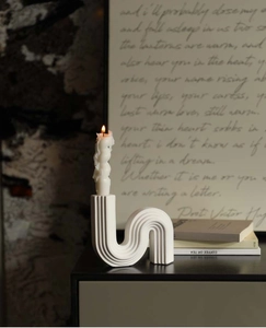 Detail of a white wave ceramic candle holder with vertical texture and spiral candle