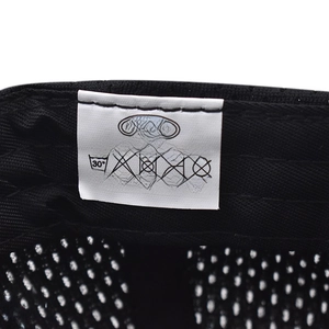 Detalle de la etiqueta de lavado de 100% algodón y textura de tela de la gorra negra