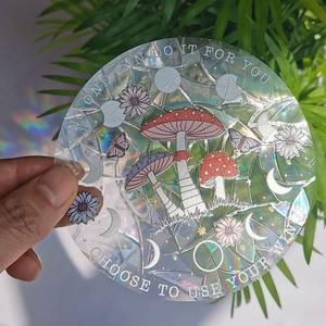 Detail of holographic mushroom suncatcher sticker with rainbow prism effect on glass