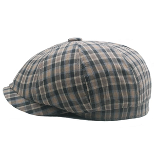 Detail of classic plaid newsboy cap showing brown checkered cotton texture and stitching
