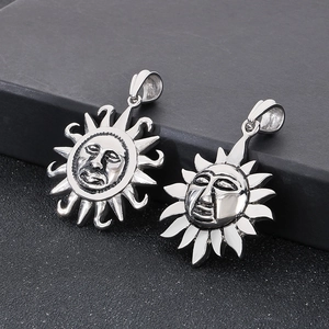 Macro shot of two silver sun face pendants with vintage and polished finishes