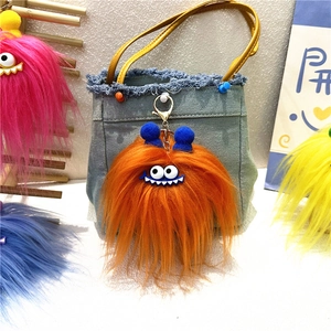 Close-up of cute furry monster bag charms with big eyes and colorful plush textures