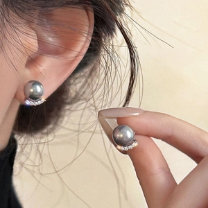 Detail of elegant grey pearl earrings with sparkling micro-pave crescent setting on ears