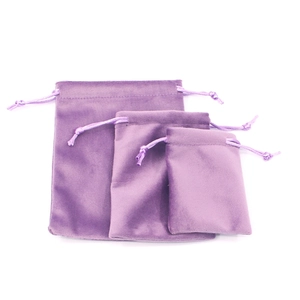 Set of three purple velvet drawstring pouches in small, medium, and large sizes on white