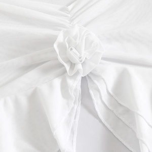 Detail of delicate white mesh swimsuit cover-up featuring a handcrafted 3D fabric rose flower