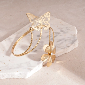 Dettaglio del bracciale da braccio a farfalla dorato traforato con piccoli cristalli
