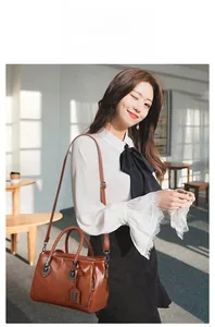 Brown woven handle boston bag with adjustable strap shown in a cozy indoor setting