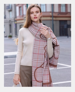 Gros plan d'une écharpe d'hiver à carreaux beige et marron avec motifs circulaires