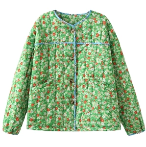 Detail view of floral quilted jacket with green flower pattern and blue contrast piping