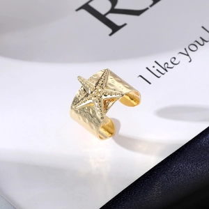 Macro shot of gold adjustable starfish ring with hammered texture and sparkling stones