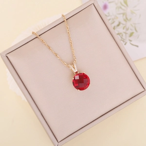 Elegant gold rope chain necklace with a faceted red round gemstone pendant in a gift box