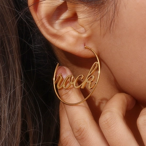 Detailed close-up of 18K gold plated hoop earring featuring rock letter cutout design