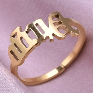 Macro shot of gold 1994 cutout year ring on pink silk background with polished finish