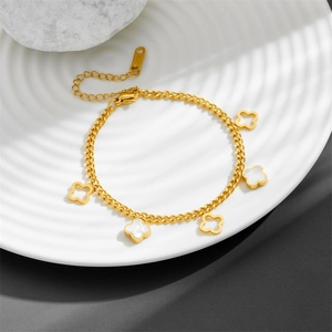 Detail of gold stainless steel four-leaf clover bracelet with white enamel charms