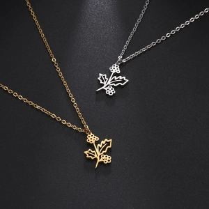 Macro detail of gold and silver stainless steel botanical pendants with cutout leaf designs