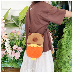 Detail of cute brown plush Capybara crossbody bag with nylon strap on floral background