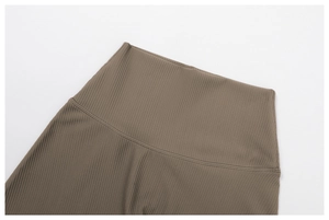Close-up of ribbed knit fabric texture and high-waist flatlock stitching on yoga shorts